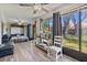 Sunroom with a murphy bed, large windows, sitting area, desk, and gray wood-look floors at 7709 Sundial Ln, Orlando, FL 32819