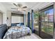 Bright bedroom with a murphy bed, dark curtain panels, large sliding glass doors, and gray floors at 7709 Sundial Ln, Orlando, FL 32819