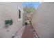 A brick-paved path leads to a decorative wrought-iron gate, set between stucco walls at 7709 Sundial Ln, Orlando, FL 32819