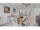 Bright dining room with a ceiling fan, painting on the wall, and gray sideboard with white wooden chairs at 7709 Sundial Ln, Orlando, FL 32819