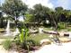 Serene water fountain with a playful statue, set amidst lush tropical landscaping, offers a tranquil outdoor retreat at 7709 Sundial Ln, Orlando, FL 32819