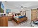 Bright main bedroom featuring a wooden bed frame, ceiling fan, and sliding wood door at 7709 Sundial Ln, Orlando, FL 32819