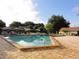 Community swimming pool with chairs and umbrellas, surrounded by a brick patio at 7709 Sundial Ln, Orlando, FL 32819