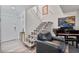 Entryway with a staircase, white railing, black leather chair, piano, and wood-look floors at 7709 Sundial Ln, Orlando, FL 32819