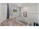 Bright hallway with white railings, wood flooring, and natural light from large windows at 7709 Sundial Ln, Orlando, FL 32819