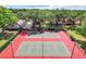 Aerial view of tennis courts in a landscaped community with mature trees and clear blue sky backdrop at 7709 Sundial Ln, Orlando, FL 32819