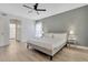 A bedroom with en-suite bath featuring a gray accent wall, a ceiling fan and a neutral color palette at 7916 Golden Pond Cir, Kissimmee, FL 34747