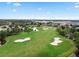 Stunning aerial view of a golf course community with lush green fairways and a lake at 8044 Saint James Way, Mount Dora, FL 32757