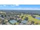 Scenic aerial view showcasing tennis courts, golf course, and lush landscaping at 8044 Saint James Way, Mount Dora, FL 32757