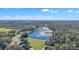 Overhead aerial view of a lake with fountain, golf course, and surrounding lush trees at 8044 Saint James Way, Mount Dora, FL 32757