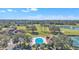 Expansive aerial shot featuring a sparkling pool, golf course, and verdant surroundings at 8044 Saint James Way, Mount Dora, FL 32757