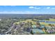 Aerial view of a community featuring a pool, tennis courts, a lake, and wooded areas at 8044 Saint James Way, Mount Dora, FL 32757