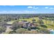 Panoramic aerial view of an estate with a large home, a golf course, and natural wooded areas at 8044 Saint James Way, Mount Dora, FL 32757