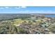 Picturesque aerial view highlighting a golf course, lake with fountain, and tree-lined streets at 8044 Saint James Way, Mount Dora, FL 32757