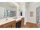 Bathroom featuring dual sinks, a large mirror, and a separate shower and tub, creating a spa-like experience at 8044 Saint James Way, Mount Dora, FL 32757