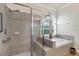 Modern bathroom featuring a glass-enclosed shower, a soaking tub, and tiled floors at 8044 Saint James Way, Mount Dora, FL 32757