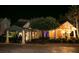 Beautifully lit exterior of a building with covered entryway and well-manicured landscaping at 8044 Saint James Way, Mount Dora, FL 32757