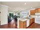 Modern kitchen with wood cabinets, white appliances, and hardwood floors at 8044 Saint James Way, Mount Dora, FL 32757