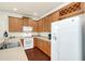 Well-lit kitchen featuring wood cabinets, modern white appliances, and a convenient wine rack at 8044 Saint James Way, Mount Dora, FL 32757