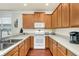 Bright kitchen with wooden cabinetry, white appliances, and gray countertops at 8044 Saint James Way, Mount Dora, FL 32757