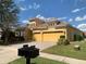 Attractive yellow two-story home featuring a three-car garage, clay roof, and well-manicured lawn at 8908 Via Bella Notte, Orlando, FL 32836