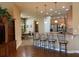 Open kitchen and dining area featuring hardwood floors, a breakfast bar, and stylish pendant lighting at 8908 Via Bella Notte, Orlando, FL 32836