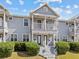 Two-story townhouse featuring a balcony, white trim, painted siding, and landscaped bushes at 945 N Fern Creek Ave, Orlando, FL 32803