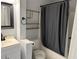 Cozy bathroom with a shower/tub combo, dark mirror, and bronze shelving unit at 1002 Stucki Ter, Winter Garden, FL 34787