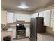 An empty kitchen featuring white cabinets and stainless steel appliances at 1002 Stucki Ter, Winter Garden, FL 34787