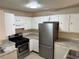 Traditional kitchen featuring white cabinets, stainless steel appliances, and a gas range stove at 1002 Stucki Ter, Winter Garden, FL 34787