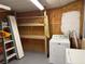 Laundry room area with wooden shelving and a washing machine at 1002 Stucki Ter, Winter Garden, FL 34787