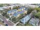 Aerial shot of a neighborhood highlighting a cluster of townhomes, surrounded by commercial buildings and lush trees at 11 W Harding St # D, Orlando, FL 32806