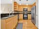 Well-lit kitchen with modern stainless steel appliances, tile backsplash, and wooden cabinets at 11 W Harding St # D, Orlando, FL 32806