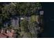 An aerial shot displaying the home, long driveway, boat dock and lush surroundings at 1100 S Lake Sybelia Dr, Maitland, FL 32751