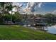 Lush green backyard that leads to a wooden dock and covered boat lift on the lake at 1100 S Lake Sybelia Dr, Maitland, FL 32751