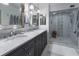 Bathroom featuring a double sink vanity, glass enclosed shower, and neutral decor at 1100 S Lake Sybelia Dr, Maitland, FL 32751