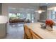 Open dining room with a farmhouse table, chairs, and views into the bright, updated kitchen at 1100 S Lake Sybelia Dr, Maitland, FL 32751