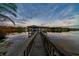 A stunning view of the covered boat dock at the end of a long wooden walkway, on the lake at 1100 S Lake Sybelia Dr, Maitland, FL 32751