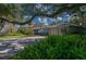 Charming home featuring a circular driveway, lush landscaping, and mature trees at 1100 S Lake Sybelia Dr, Maitland, FL 32751