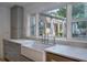 Bright kitchen featuring a farmhouse sink, marble countertops, and lush landscaping visible through the window at 1100 S Lake Sybelia Dr, Maitland, FL 32751