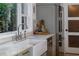 Close-up view of the kitchen sink with marble countertops and a view of lush greenery outside at 1100 S Lake Sybelia Dr, Maitland, FL 32751