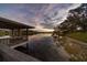 Picturesque waterfront view with a covered dock and serene lake reflections at twilight at 1100 S Lake Sybelia Dr, Maitland, FL 32751