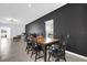 Modern dining room featuring a dark accent wall, dining table set, and open view to living space at 1139 James Paul Rd, Davenport, FL 33837