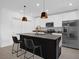 Modern kitchen featuring stainless steel appliances, black island, pendant lights, and white cabinetry at 1139 James Paul Rd, Davenport, FL 33837