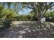 Large private backyard, lush landscaping, mature shade trees, and a storage shed create a serene outdoor space at 117 Shannon Dr, Sanford, FL 32773