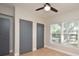 An empty bedroom features neutral walls, wood-look flooring, two gray closets and a window at 117 Shannon Dr, Sanford, FL 32773