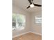 A minimalist bedroom featuring a ceiling fan, neutral walls, wood-look flooring, and two windows at 117 Shannon Dr, Sanford, FL 32773