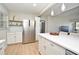 Bright kitchen featuring stainless steel refrigerator, white cabinets, shelving, and a view into the living area at 117 Shannon Dr, Sanford, FL 32773