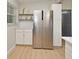 A kitchen shows white cabinets, shelving, stainless steel refrigerator and wood-look flooring at 117 Shannon Dr, Sanford, FL 32773