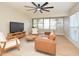 Bright living room featuring a ceiling fan, light wood floors, a leather couch, and natural light at 117 Shannon Dr, Sanford, FL 32773